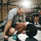 Man attempting to pickup a barbell